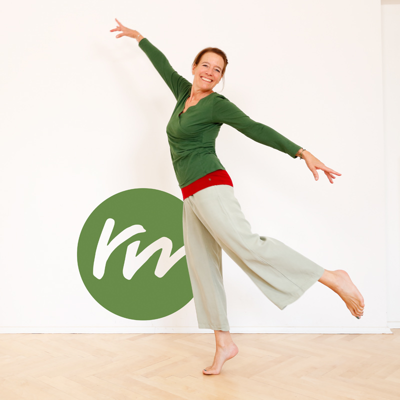 Regine Meier in Yogakleidung, ein Bein abgewinkelt vor Logo